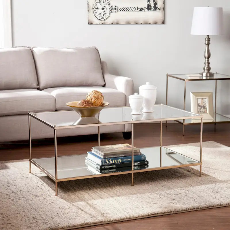 Rechthoekige salontafel van SEI Furniture Grant met goudkleurige afwerking, glazen bovenblad en onderste legplank